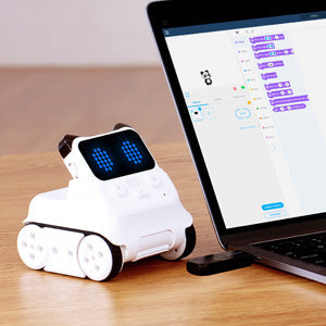 Robotic toy next to a laptop on a wooden surface
